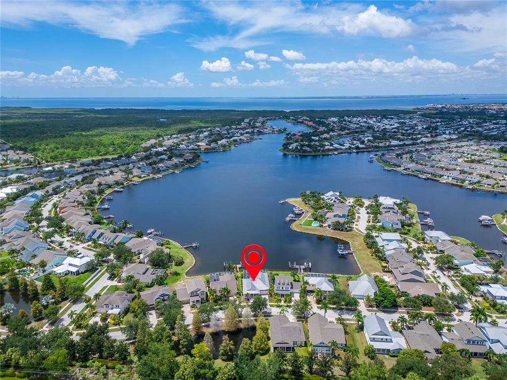 An aerial view shows a waterfront house with a red location marker on a lake — 429 MANNS HARBOR DRIVE, APOLLO BEACH, FL