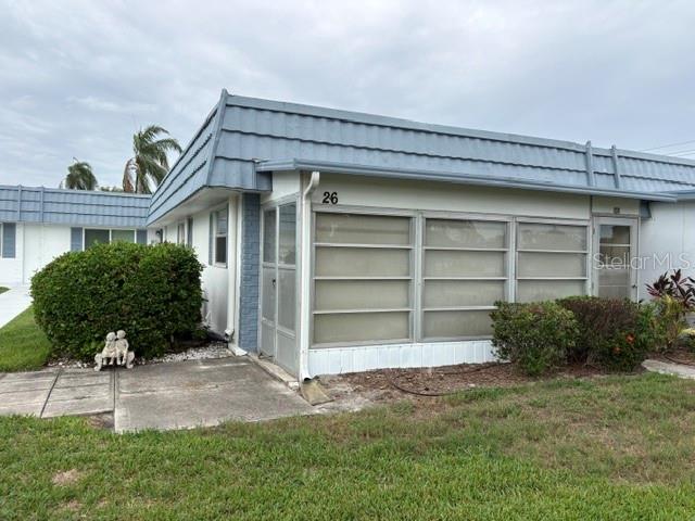 A single-story residential unit with a blue mansard roof and a screened-in porch — 1901 ANDOVER WAY UNIT 26, SUN CITY CENTER, FL