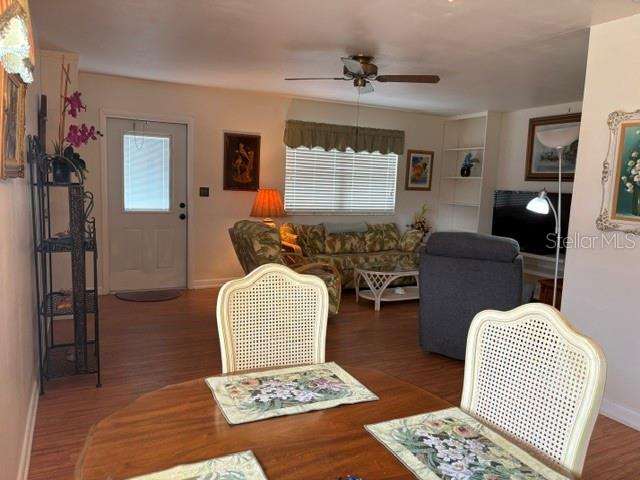 A dining area with a wooden table overlooks a living room featuring a sofa and recliner — 1901 ANDOVER WAY UNIT 26, SUN CITY CENTER, FL