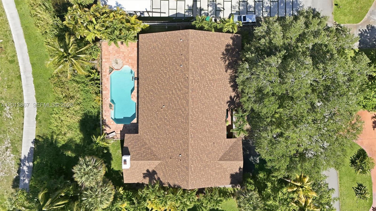 An aerial view shows a house with a brown roof, a pool, and surrounding trees — 7200 N Oakmont Dr, Hialeah FL 33015, HIALEAH, FL