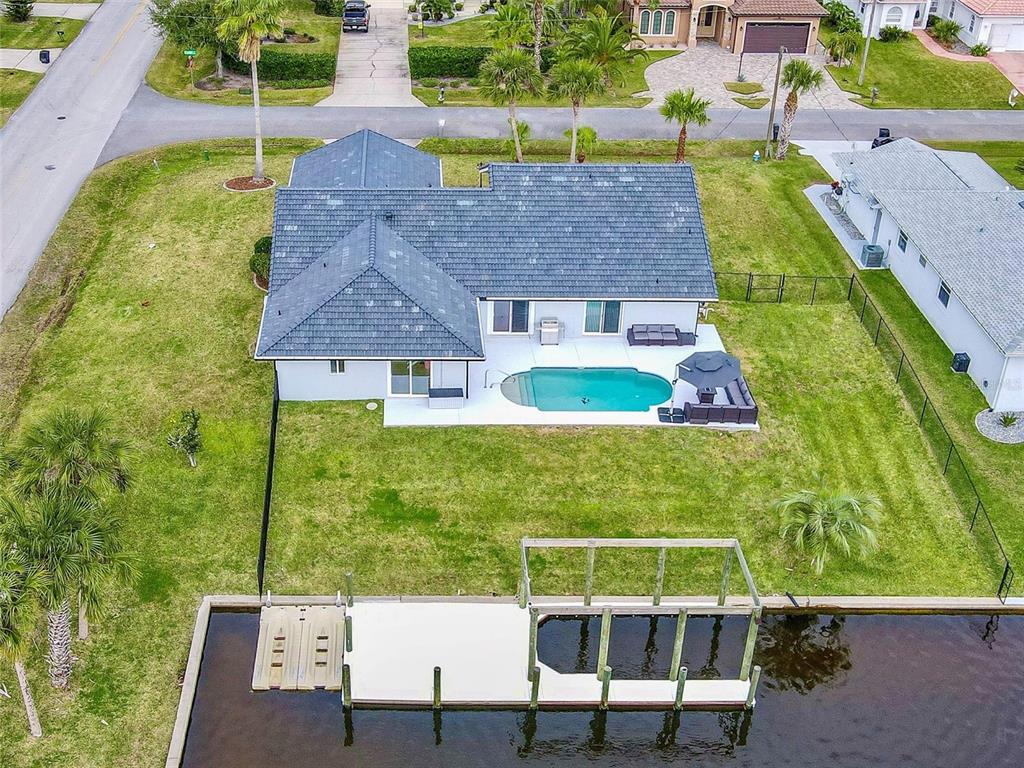 An aerial view of a house with a swimming pool, backyard, and a private boat dock — 2 CEDAR COURT, PALM COAST, FL