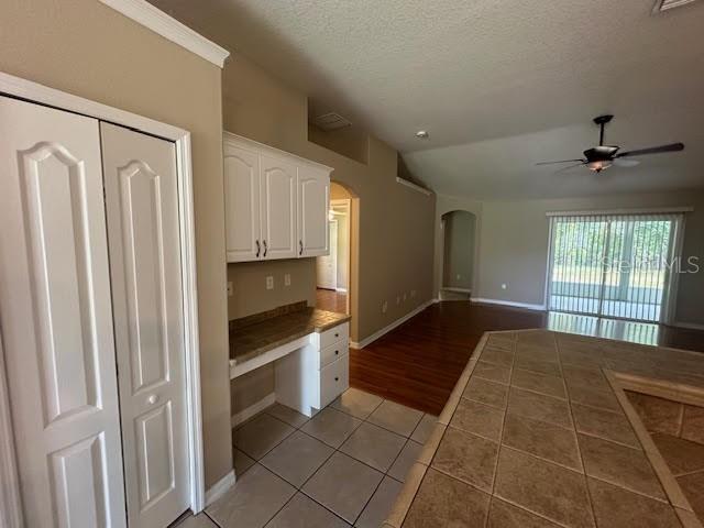 A kitchen area features tile flooring, white cabinetry, a built-in desk, and a ceiling fan — 31 RYMER LANE, PALM COAST, FL