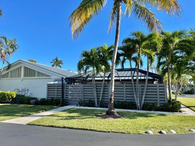 A white house with a metal roof is partially obscured by a gray privacy fence — 1801 S Us Highway 1 # 17c, Jupiter FL 33477, JUPITER, FL