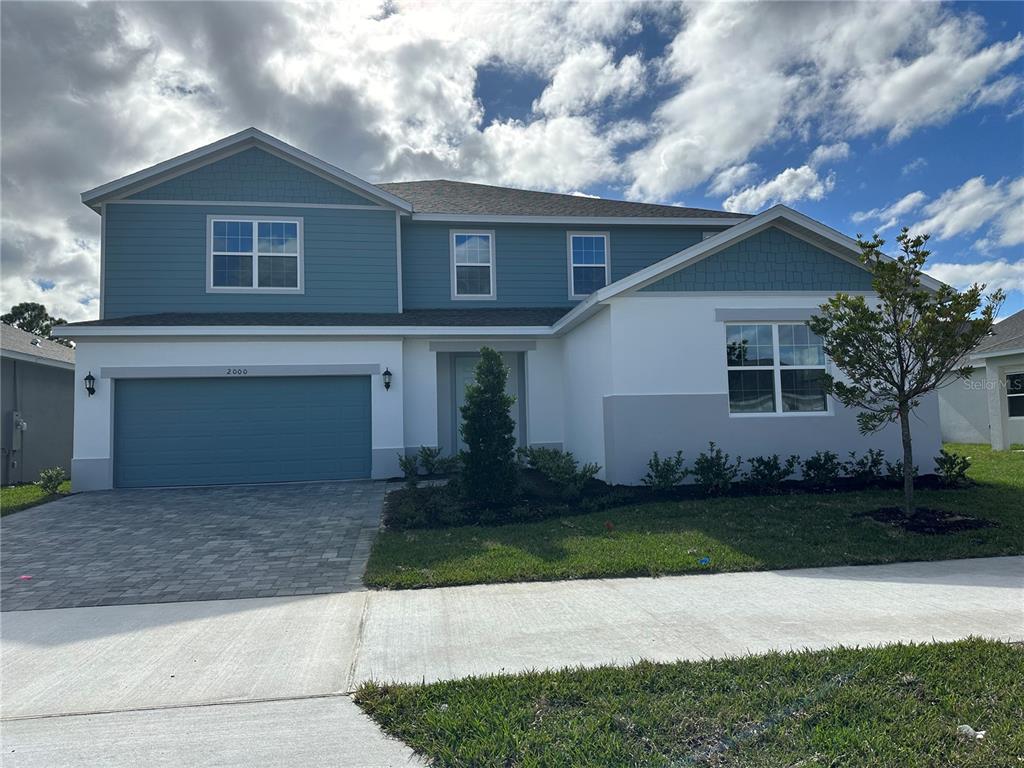 A two-story house with blue siding, white stucco, and a paved driveway — 2000 BEEVALLEY WAY, DELAND, FL
