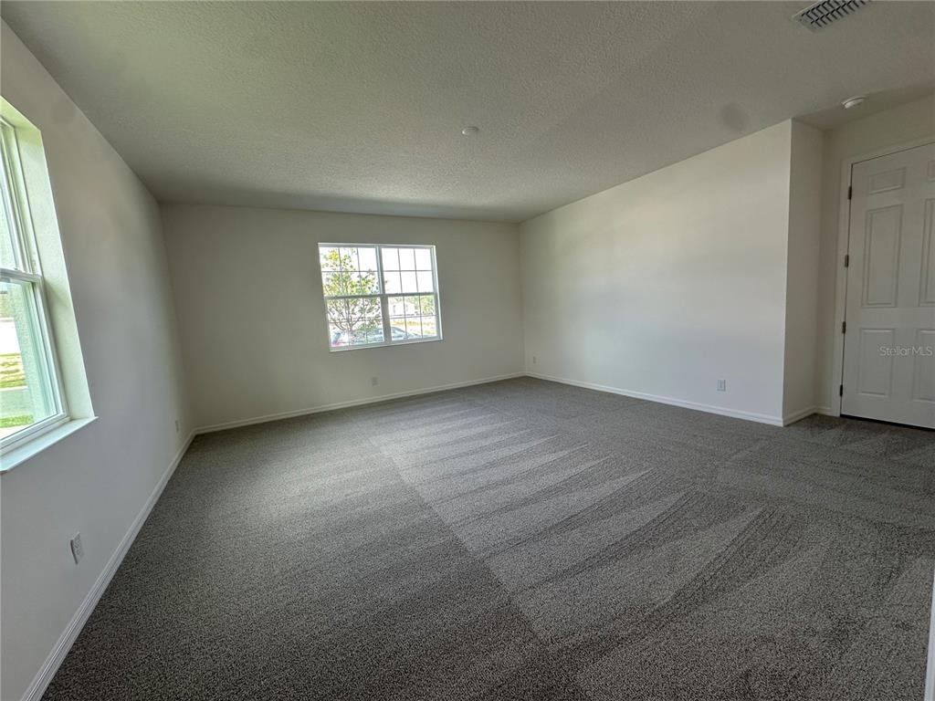 An empty room with gray carpet, white walls, and two windows — 2000 BEEVALLEY WAY, DELAND, FL