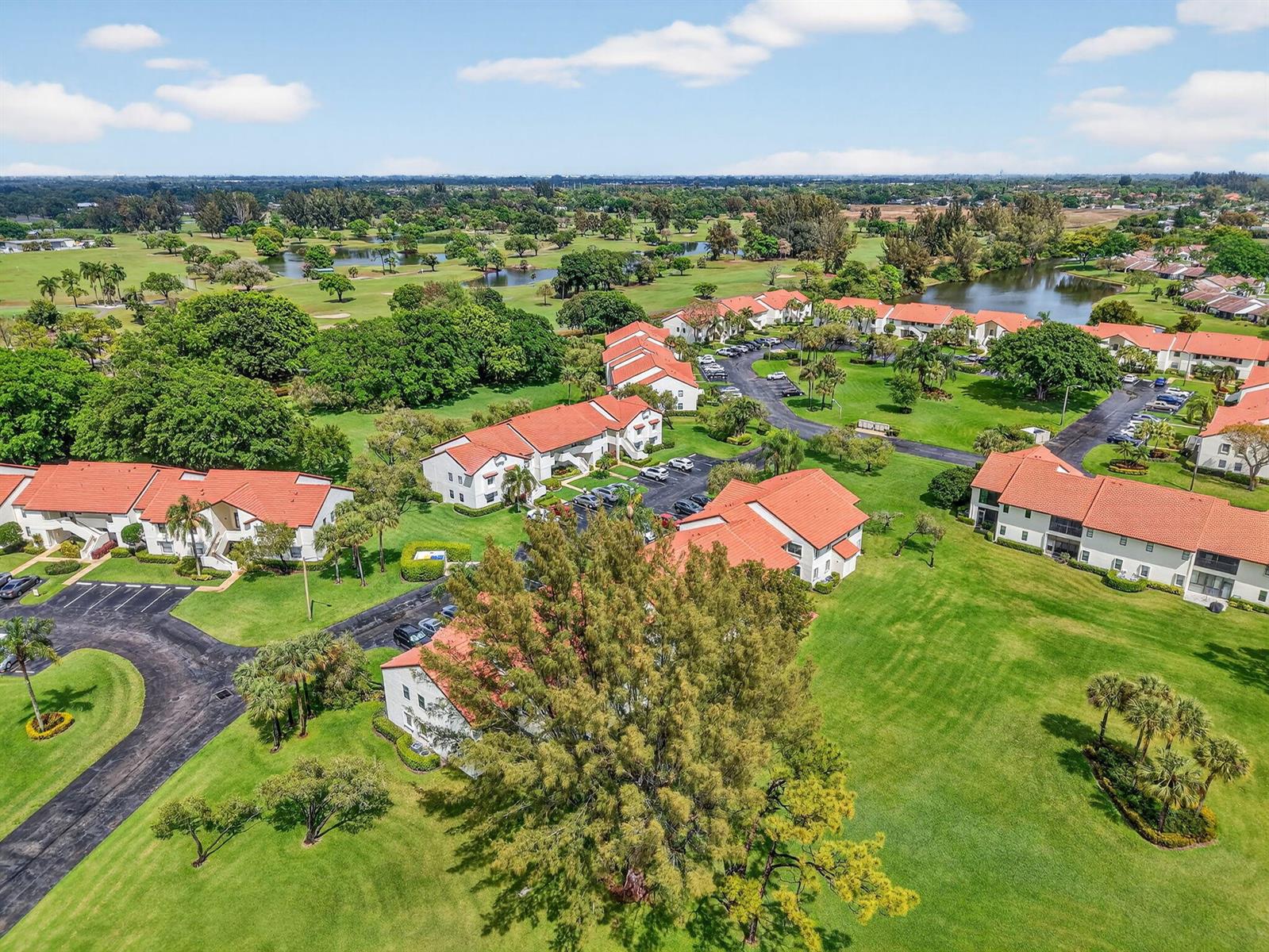 An aerial view shows multiple apartment buildings with red tile roofs surrounded by green lawns — 6069 Parkwalk Drive, Boynton Beach FL 33472, BOYNTON BEACH, FL