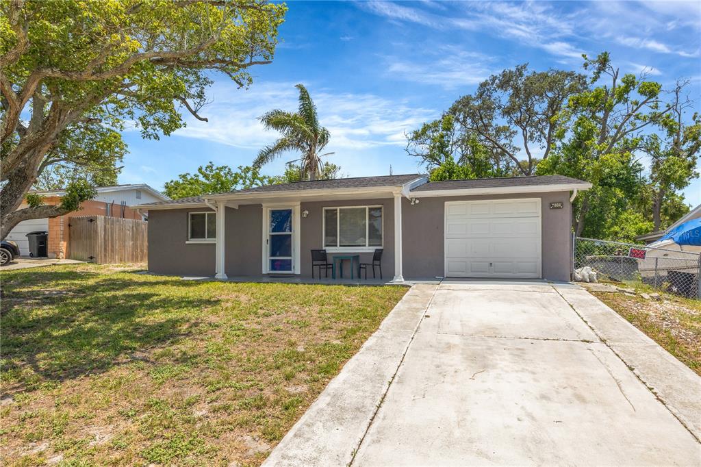A single-story gray house with a white garage door and a concrete driveway — 7804 NIAGARA DRIVE, PORT RICHEY, FL