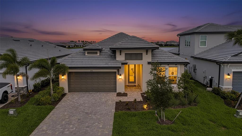 A single-story house with a gray tile roof, a two-car garage, and a paved driveway — 17241 SAVORY MIST CIRCLE, BRADENTON, FL