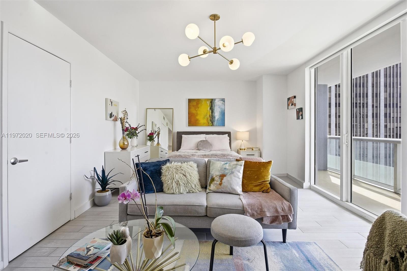A studio apartment features a bed, a sofa, a glass coffee table, and a balcony — 50 Biscayne Blvd # 1909, Miami FL 33132, MIAMI, FL