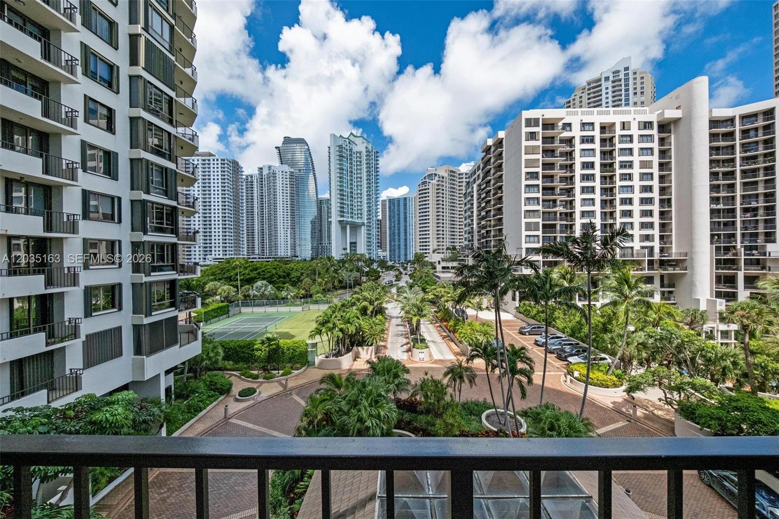 A high-angle view shows a tennis court and landscaped grounds surrounded by tall apartment buildings — 520 Brickell Key Dr # A710, Miami FL 33131, MIAMI, FL