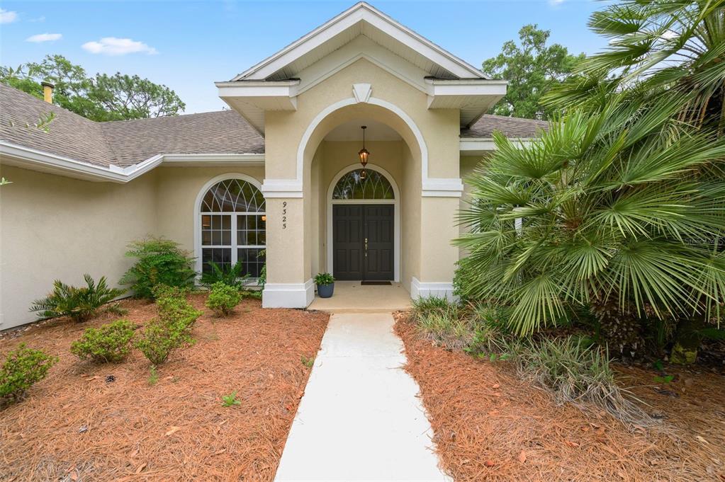 A kitchen with wood cabinets, granite countertops, stainless steel appliances, and tile flooring — 9325 SW 35TH LANE, GAINESVILLE, FL