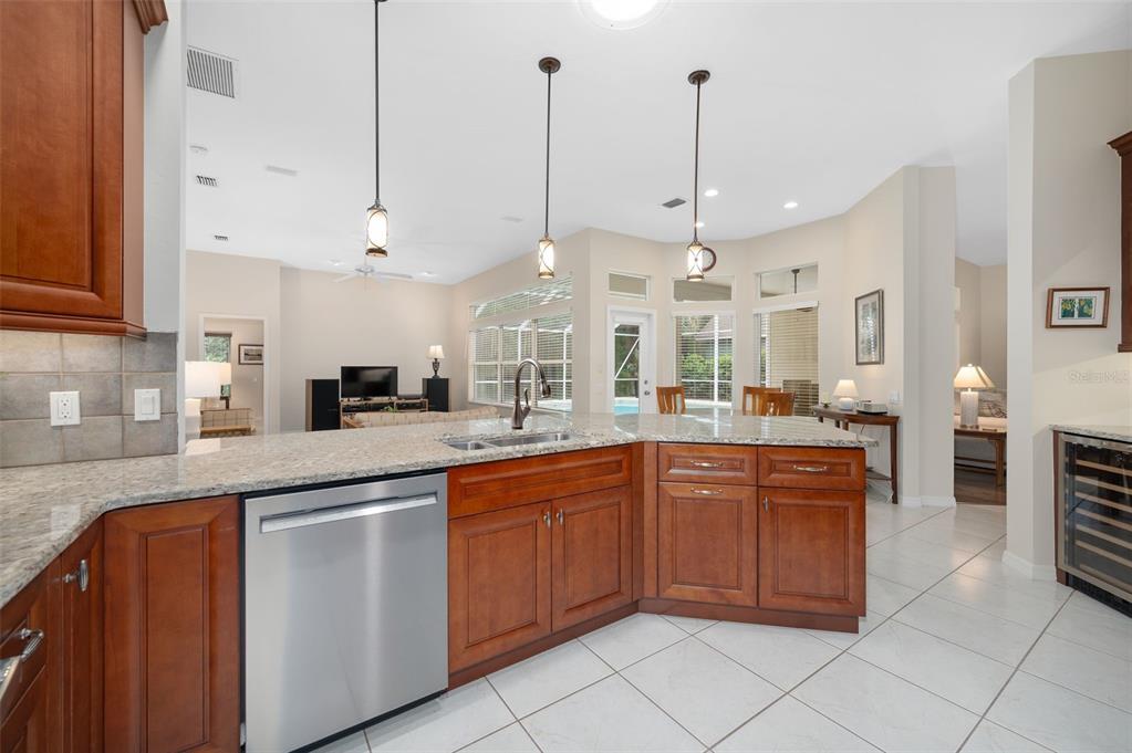 A kitchen features cherry wood cabinets, granite countertops, a wine cooler, and a dining area — 9325 SW 35TH LANE, GAINESVILLE, FL