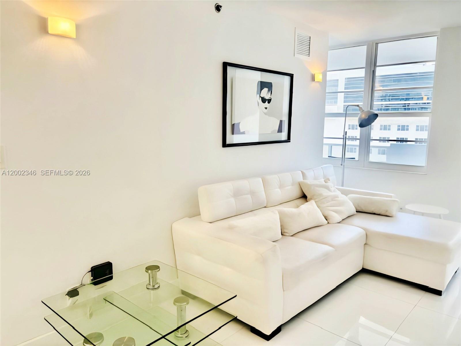 A white sectional sofa sits in a bright living room with a glass coffee table — 100 Lincoln Rd # 927, Miami Beach FL 33139, MIAMI BEACH, FL