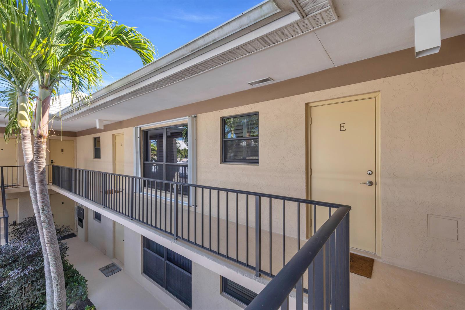 An exterior view of a multi-story apartment building with a balcony and palm tree — 4 SE Turtle Creek Drive, Jupiter FL 33469, JUPITER, FL