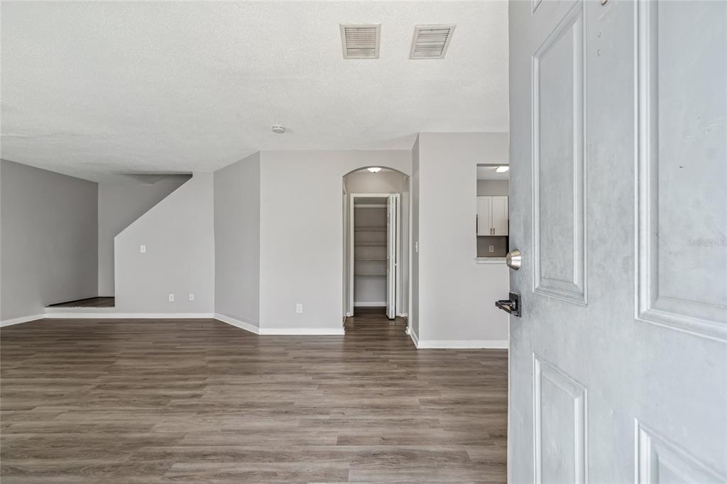 A view from an open doorway into a living area with gray walls and flooring — 7402 E BANK DRIVE, TAMPA, FL
