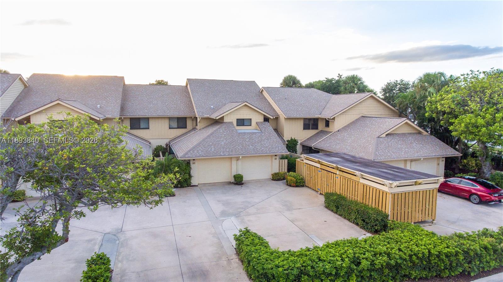 An aerial view shows a multi-unit residential building with attached garages and a wooden fence — 17081 Waterbend Dr # 227, Jupiter FL 33477, JUPITER, FL