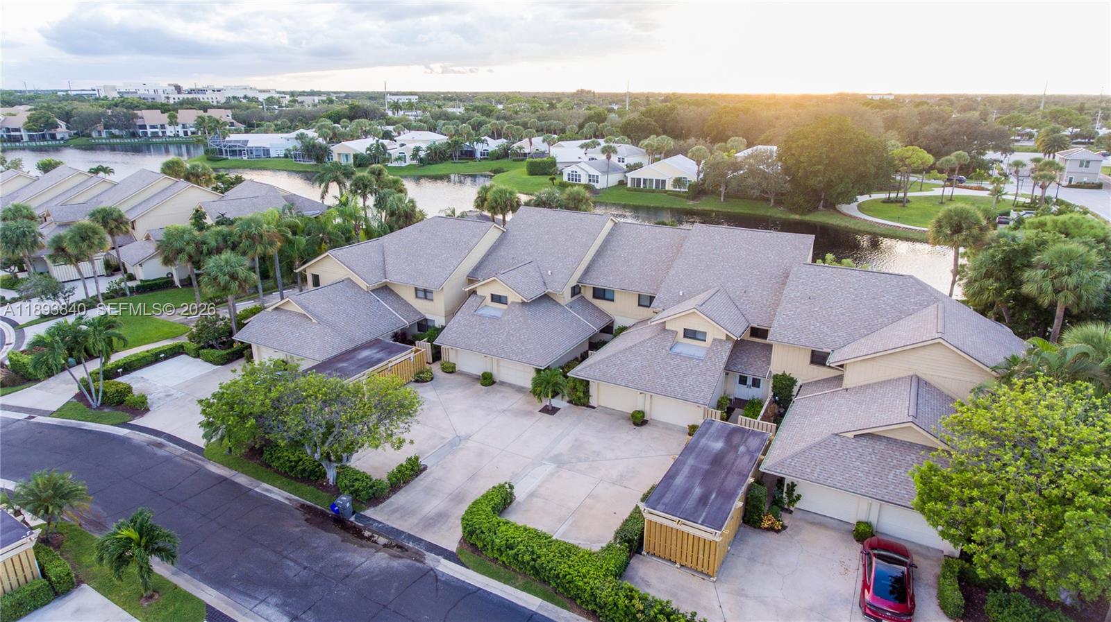 An aerial view shows a multi-unit residential building with attached garages and a nearby pond — 17081 Waterbend Dr # 227, Jupiter FL 33477, JUPITER, FL