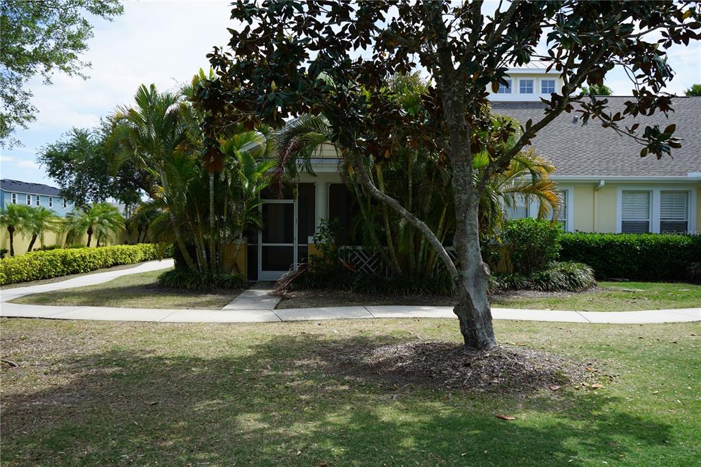 A yellow building with a screened-in porch is surrounded by palm trees and landscaping — 201 SUNSET CREST COURT, APOLLO BEACH, FL