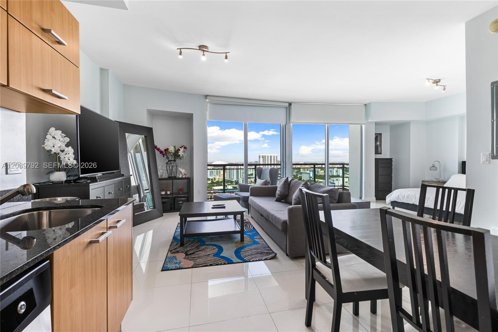 A studio apartment features a kitchen, living area, and bedroom with floor-to-ceiling windows — 350 S Miami Ave # 2815, Miami FL 33130, MIAMI, FL