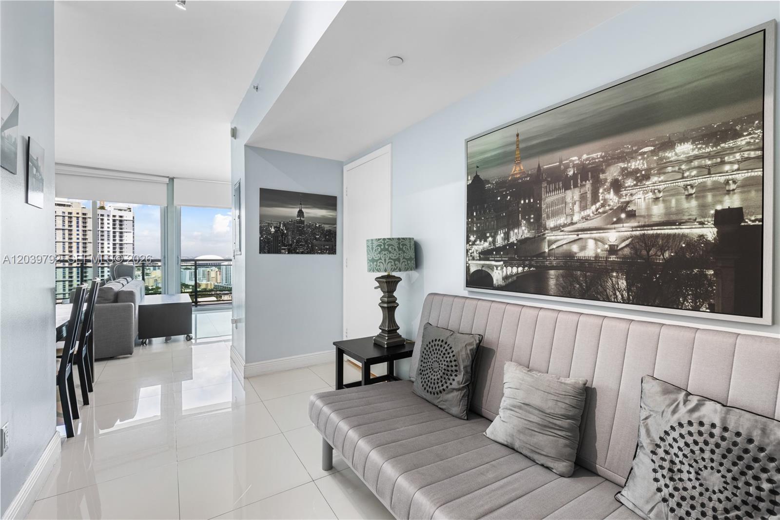 A modern living area features a gray sofa, a side table with a lamp, and artwork — 350 S Miami Ave # 2815, Miami FL 33130, MIAMI, FL