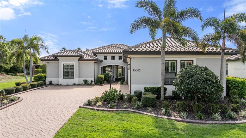 A single-story house with a paved driveway, palm trees, and a tiled roof — 16316 CASTLE PARK TERRACE, LAKEWOOD RANCH, FL
