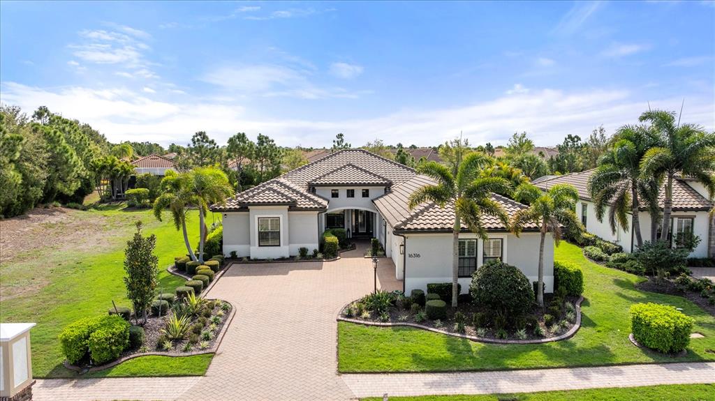 An aerial view of a single-story house with a tiled roof and paved driveway — 16316 CASTLE PARK TERRACE, LAKEWOOD RANCH, FL