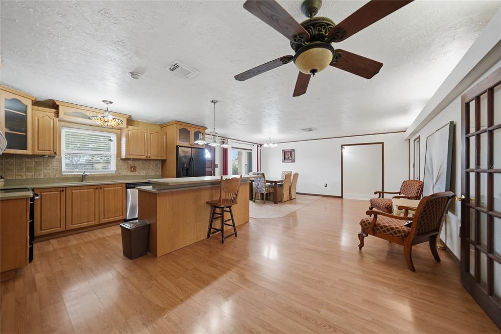 A kitchen with light wood cabinets and a breakfast bar opens into a dining area — 3250 SANTA BARBARA DRIVE, PUNTA GORDA, FL