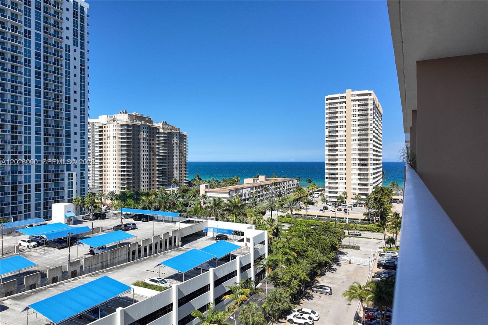 A high-angle view shows a parking structure, surrounding buildings, and the ocean beyond — 1965 S Ocean Dr # 9L, Hallandale Beach FL 33009, HALLANDALE BEACH, FL