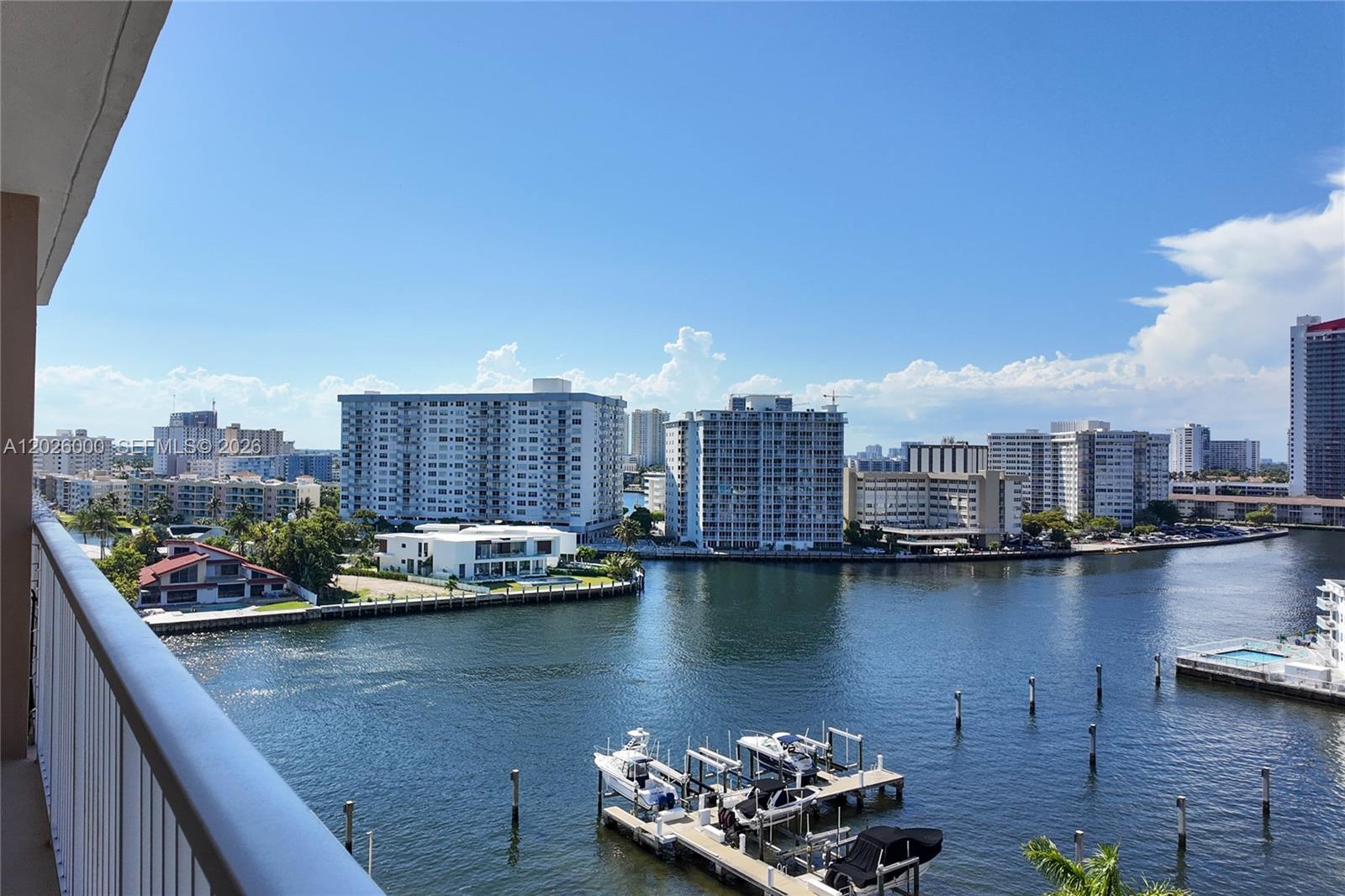 A high-angle view shows a waterway with boat docks and surrounding residential buildings under a sky — 1965 S Ocean Dr # 9L, Hallandale Beach FL 33009, HALLANDALE BEACH, FL