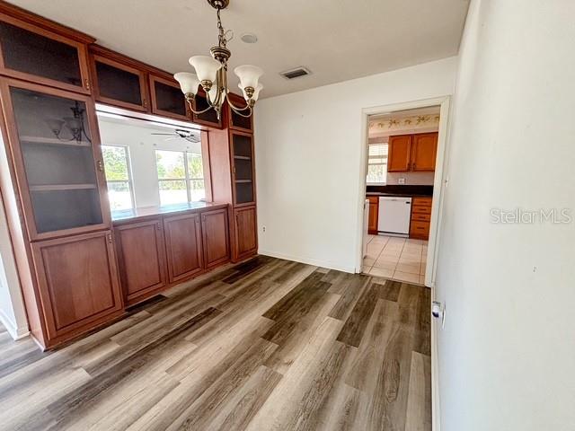 A dining area features wood-look flooring, a built-in hutch, and a doorway to the kitchen — 121 E PINE ST, HOWEY IN THE HILLS, FL