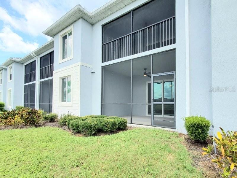 The exterior of a light blue two-story building features screened-in porches on both levels — 14194 HERITAGE LANDING BOULEVARD UNIT 611, PUNTA GORDA, FL