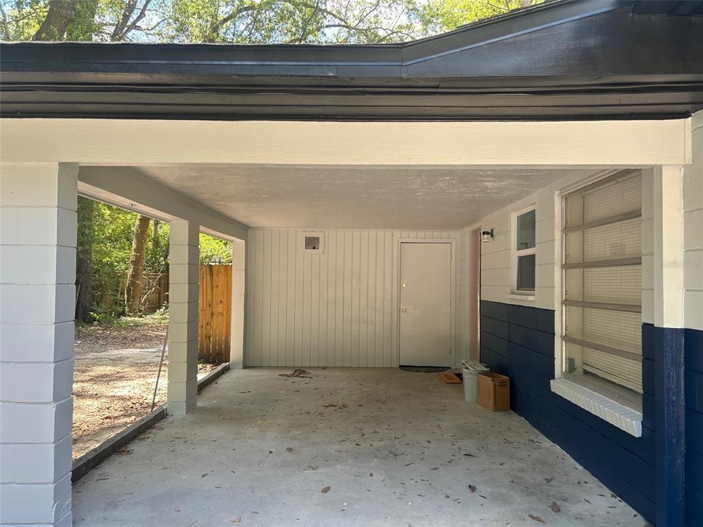 The exterior of a house features a bright orange front door and a tiled porch — 3035 W UNIVERSITY AVENUE, GAINESVILLE, FL