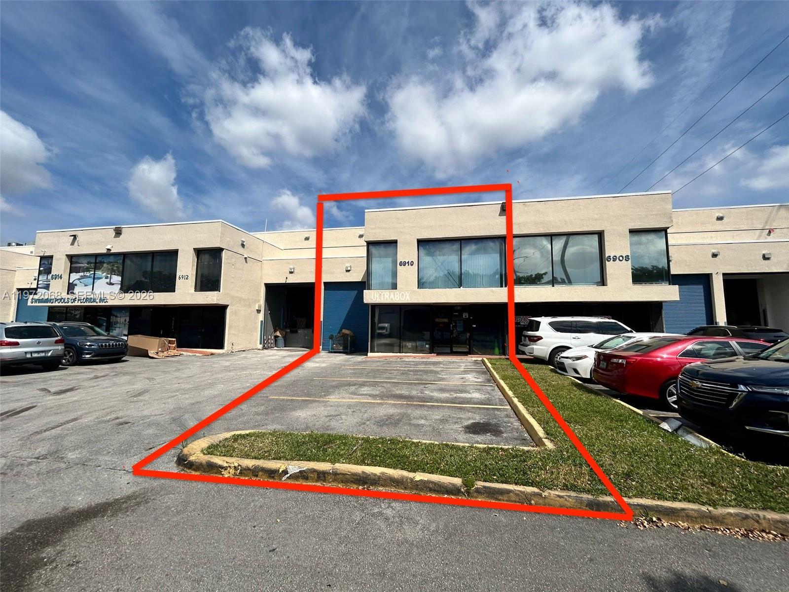 A two-story commercial building exterior features a highlighted parking space and entrance at 6910 — 6910 NW 50th St # 1, Miami FL 33195, MIAMI, FL