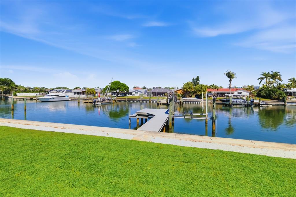 A grassy lawn overlooks a canal with a private dock and several moored boats — 4462 39TH STREET S, ST PETERSBURG, FL