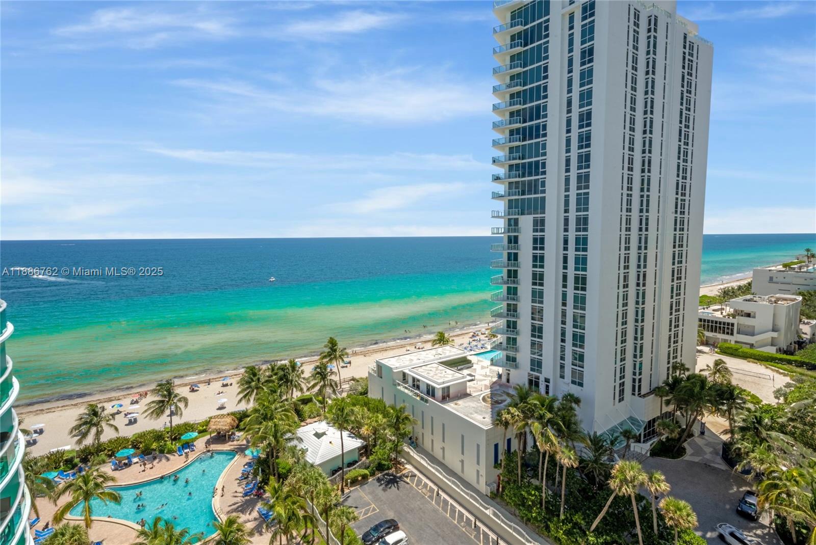 An aerial view shows a tall white residential building next to a beach and pool — 3901 S Ocean Dr # 14L, Hollywood FL 33019, HOLLYWOOD, FL