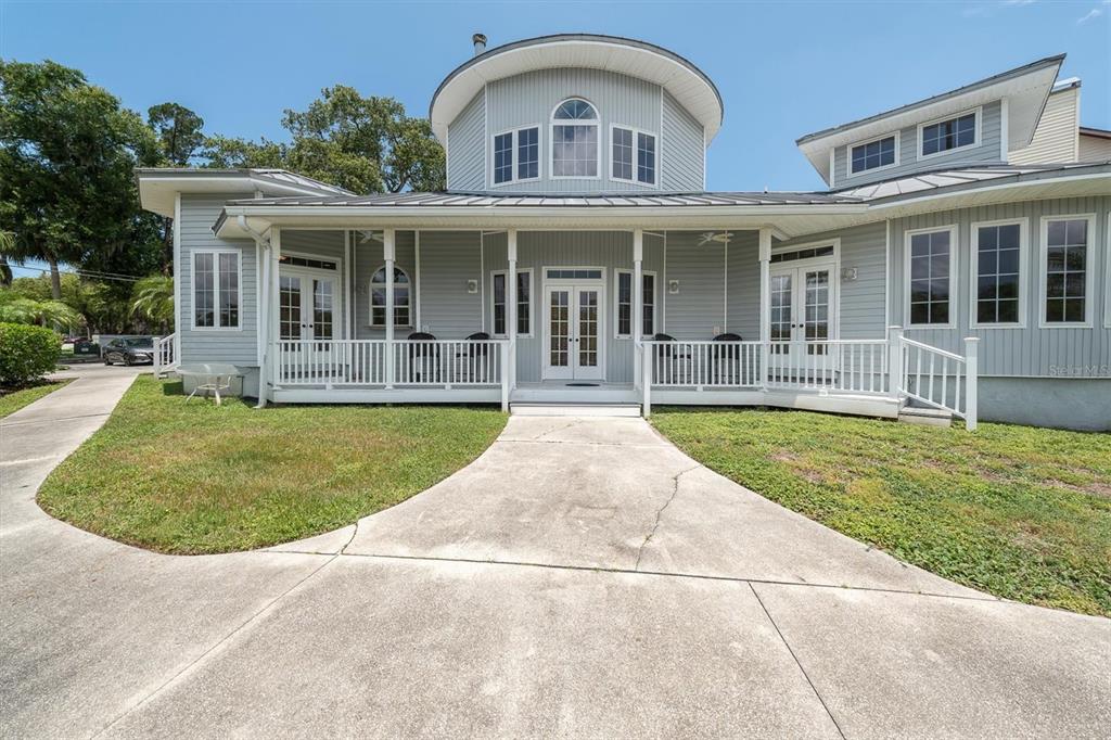 A light gray house with a circular upper level and a covered front porch — 5617 PALMETTO ROAD, NEW PORT RICHEY, FL