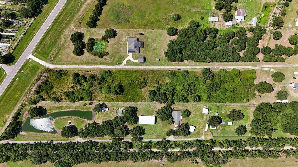 An aerial view shows two rural properties with houses, outbuildings, ponds, and wooded areas — 14775 US HIGHWAY 301 N, PARRISH, FL