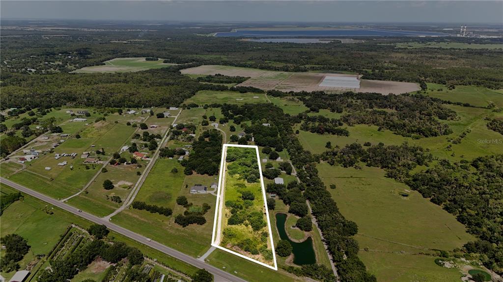 An aerial view shows a rectangular plot of land outlined in white amidst rural fields — 14775 US HIGHWAY 301 N, PARRISH, FL