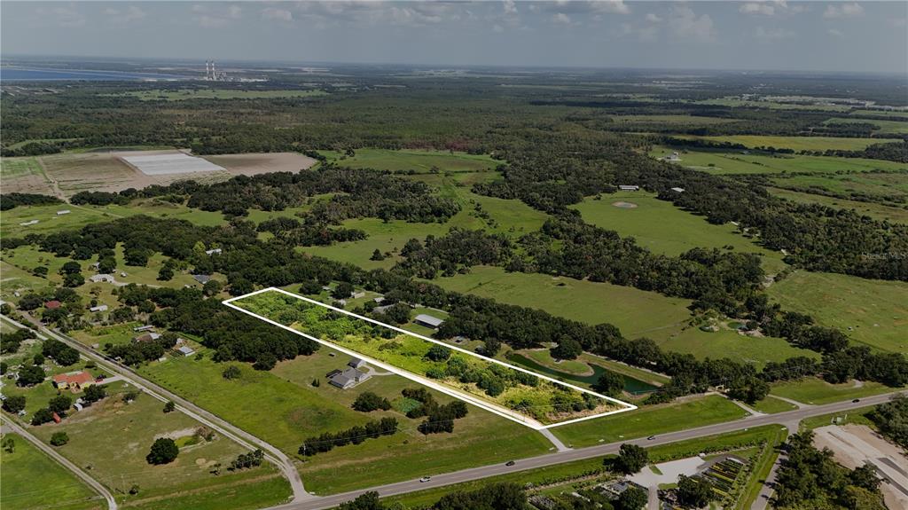 An aerial view shows a rectangular plot of land outlined in white near a road — 14775 US HIGHWAY 301 N, PARRISH, FL