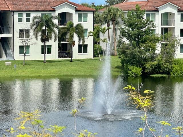 A fountain sprays water in a pond in front of two multi-story apartment buildings — 110 Villa Circle # 110, Boynton Beach FL 33435, BOYNTON BEACH, FL