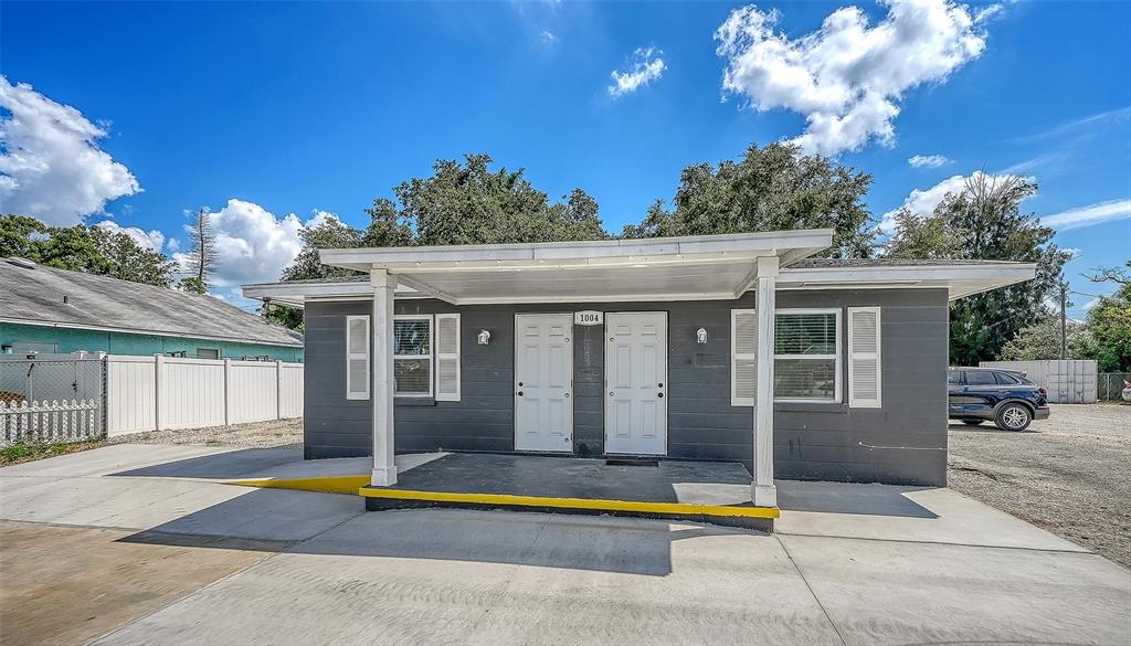A single-story gray building with two front doors, a covered porch, and a concrete ramp — 1004 27TH AVENUE W, BRADENTON, FL