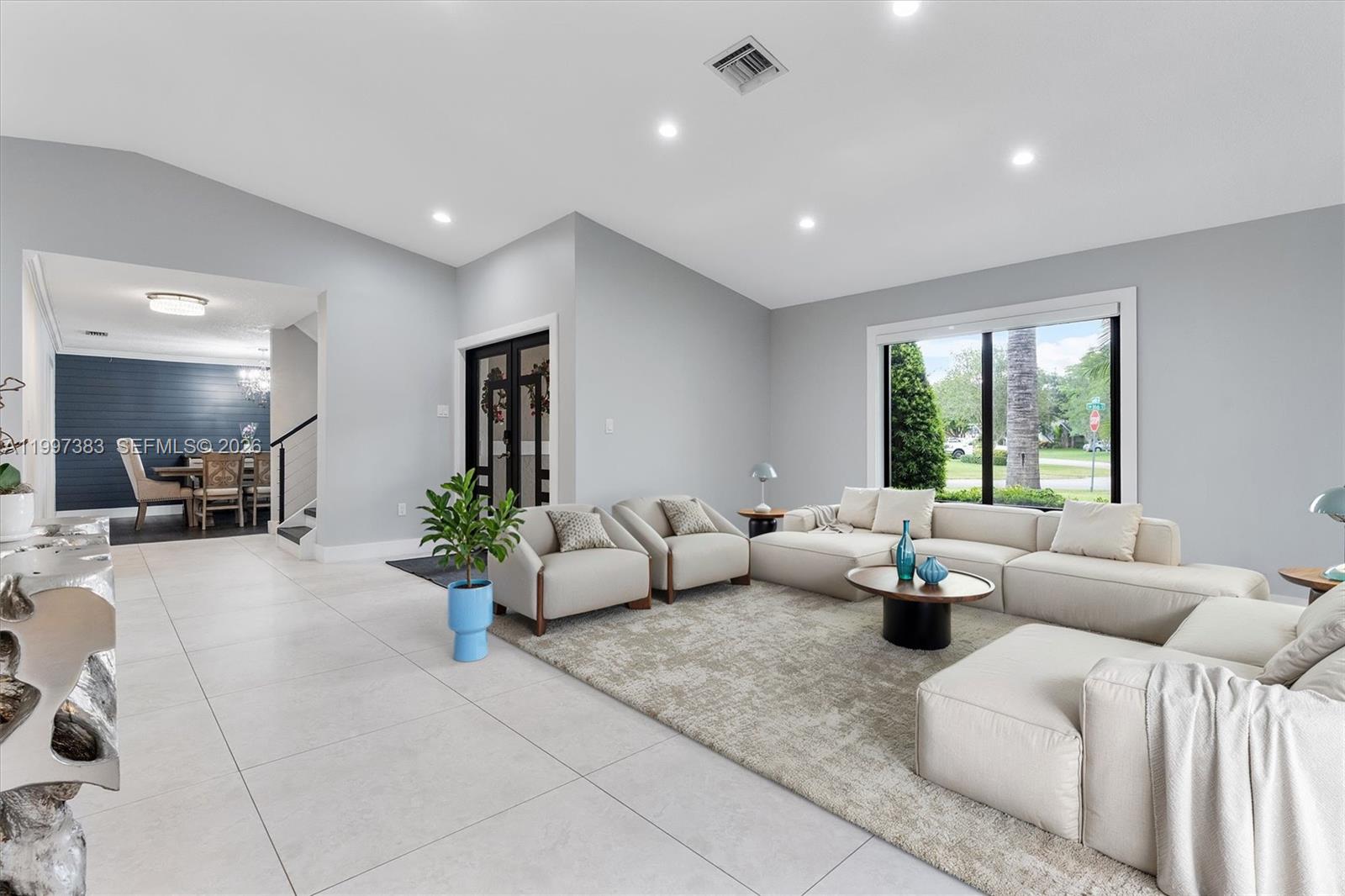 A spacious living room features light tile floors, a large sectional sofa, and vaulted ceilings — 14800 SW 166th St, Miami FL 33187, MIAMI, FL