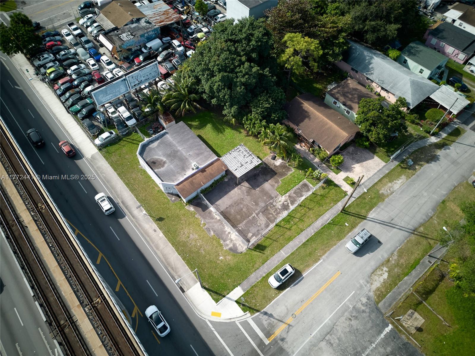 An aerial view shows a commercial building with a parking lot next to residential houses — 5832 NW 27th Ave, Miami FL 33142, MIAMI, FL