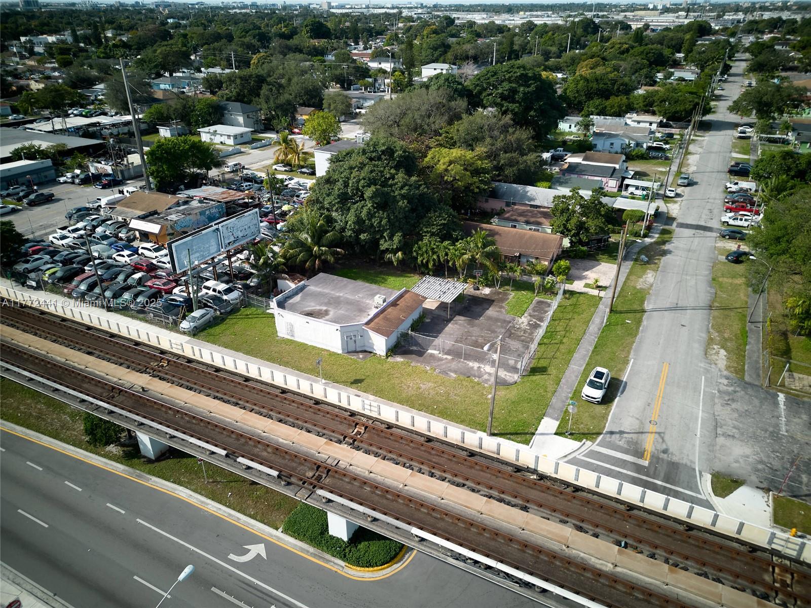 An aerial view shows a small commercial building next to train tracks and a parking lot — 5832 NW 27th Ave, Miami FL 33142, MIAMI, FL