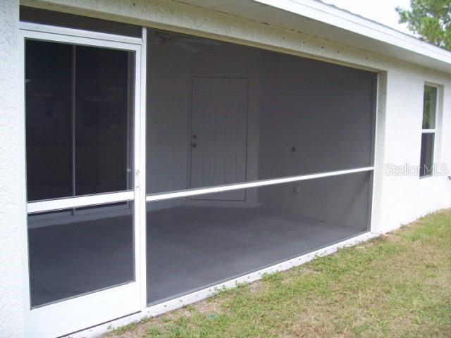 A screened-in patio with a white frame and a door attached to a house exterior — 1491 GLENVIEW ROAD, NORTH PORT, FL