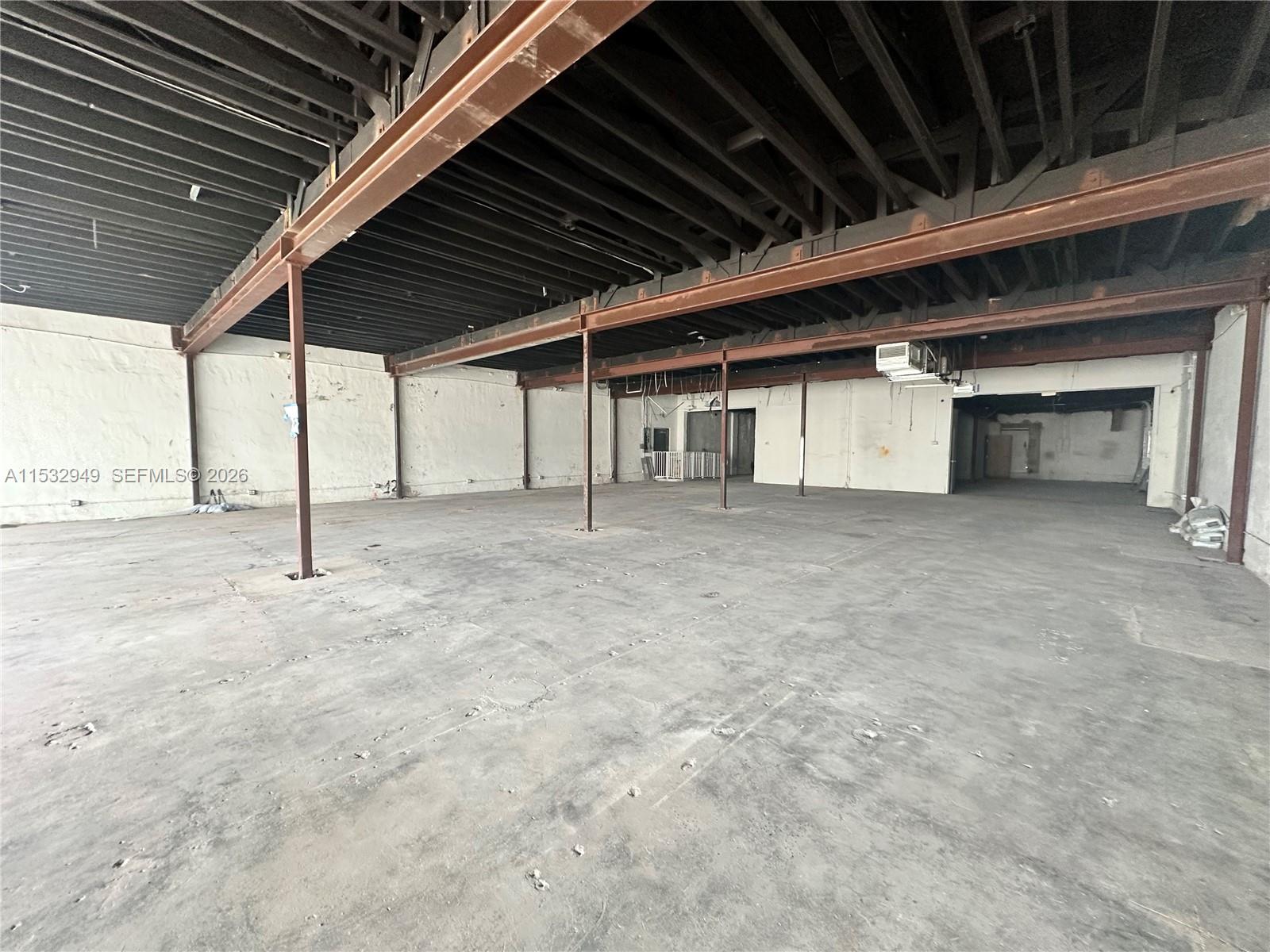 An empty industrial warehouse space features exposed steel beams, concrete floors, and white walls — 2020 Harrison St, Hollywood FL 33020, HOLLYWOOD, FL