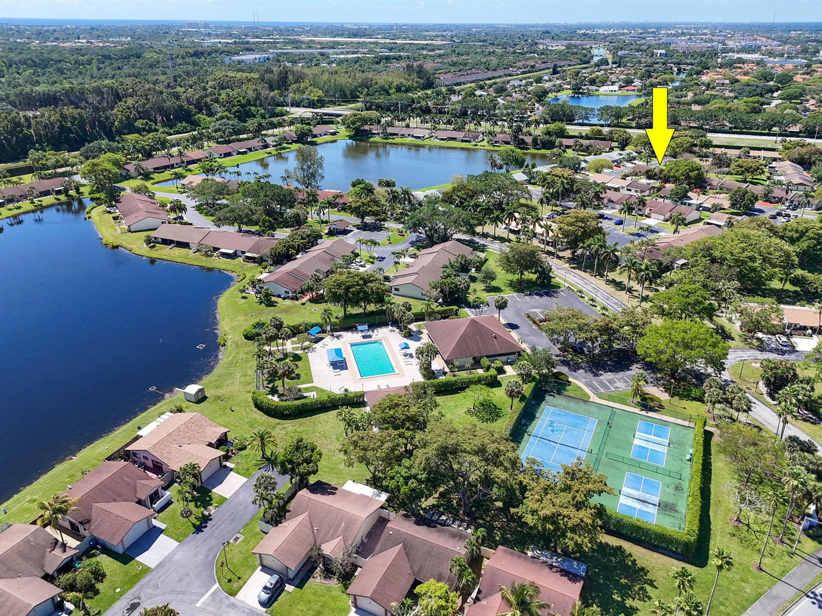 Aerial view of a residential community featuring a pool, tennis courts, and a large lake — 4 Knightsbridge Lane, Boynton Beach FL 33426, BOYNTON BEACH, FL