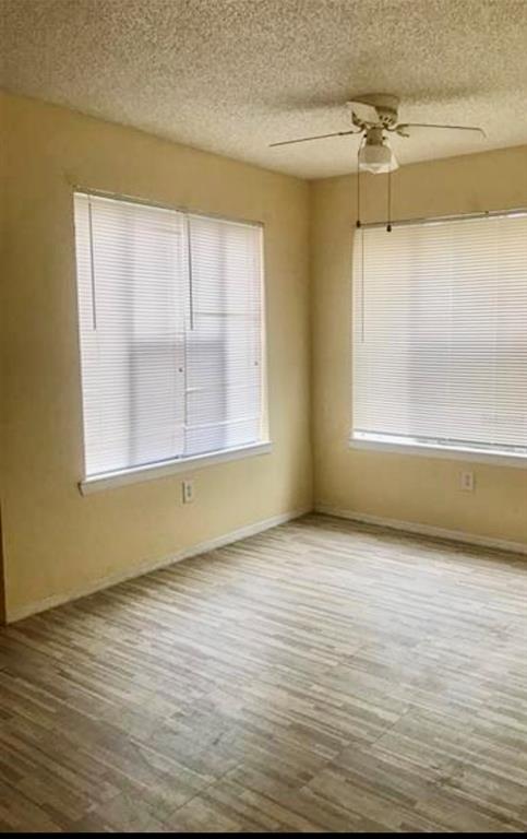 An empty room with light wood-look flooring, two windows with blinds, and a ceiling fan — 2217 GRAND CAYMAN COURT UNIT 1218, KISSIMMEE, FL