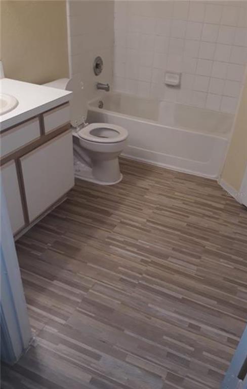 A bathroom features a white vanity, a toilet, and a bathtub with white wall tiles — 2217 GRAND CAYMAN COURT UNIT 1218, KISSIMMEE, FL