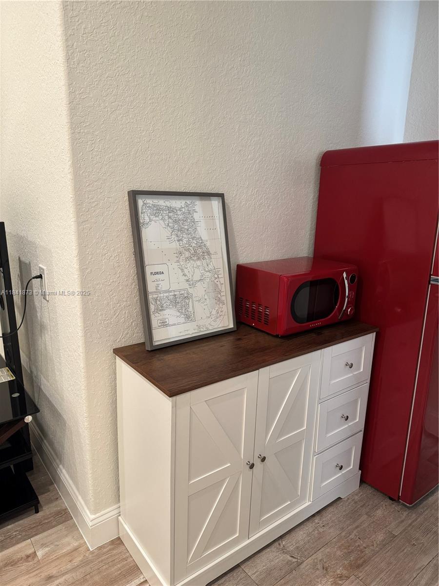 A white cabinet with a wood top holds a framed Florida map and red microwave — 15603 SW 178th St, Miami FL 33187, MIAMI, FL